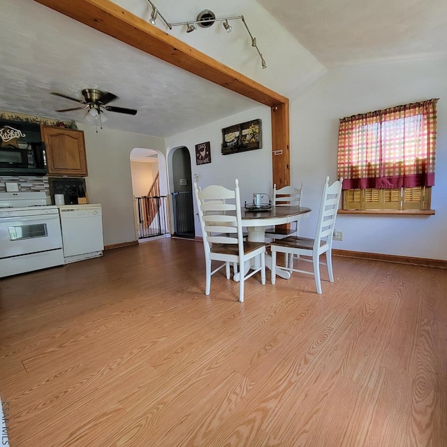 dining area featuring ceiling fan, lofted ceiling, and light wood-type flooring