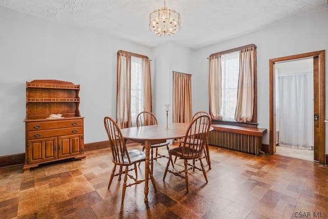 dining space with radiator, a chandelier, and a textured ceiling