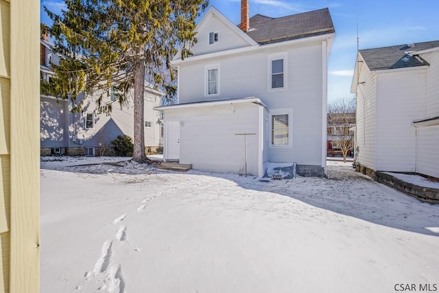 snow covered property featuring a garage