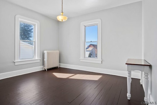 unfurnished room featuring radiator and dark hardwood / wood-style floors