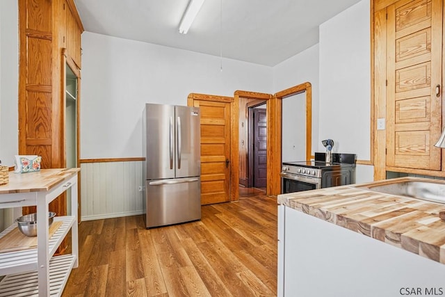 kitchen with stainless steel appliances, wood-type flooring, and sink