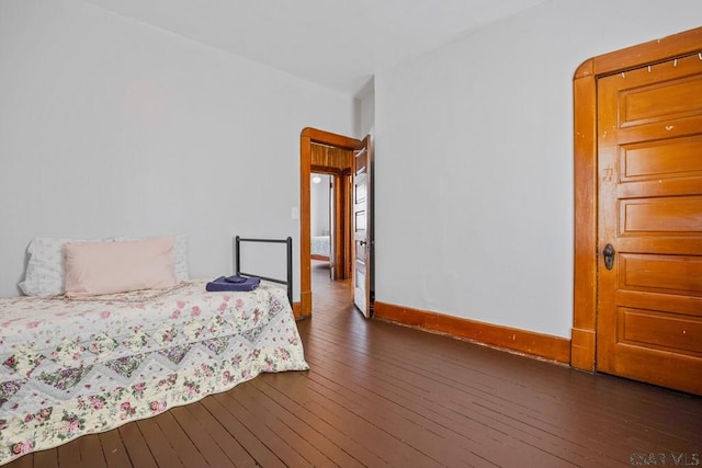 bedroom with dark hardwood / wood-style floors