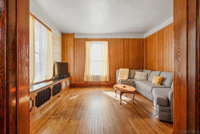 sitting room with light hardwood / wood-style floors and wood walls