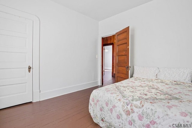 bedroom with dark wood-type flooring