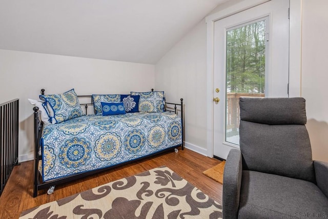 bedroom with lofted ceiling, baseboards, and wood finished floors