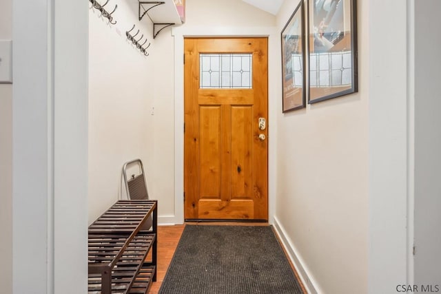 doorway to outside featuring lofted ceiling, dark wood finished floors, and baseboards