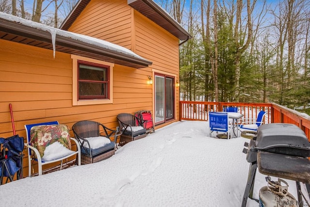 snow covered deck featuring a grill