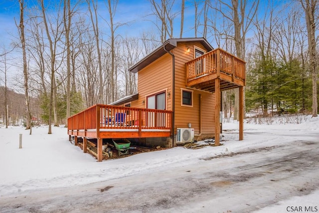 snow covered property featuring ac unit and a wooden deck