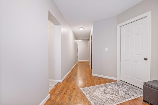 hallway with light wood-style flooring and baseboards