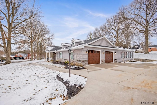 view of front facade with stone siding, driveway, and a garage