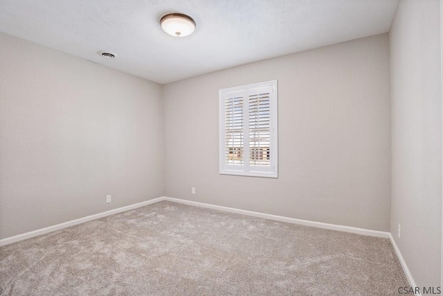 carpeted empty room featuring visible vents and baseboards