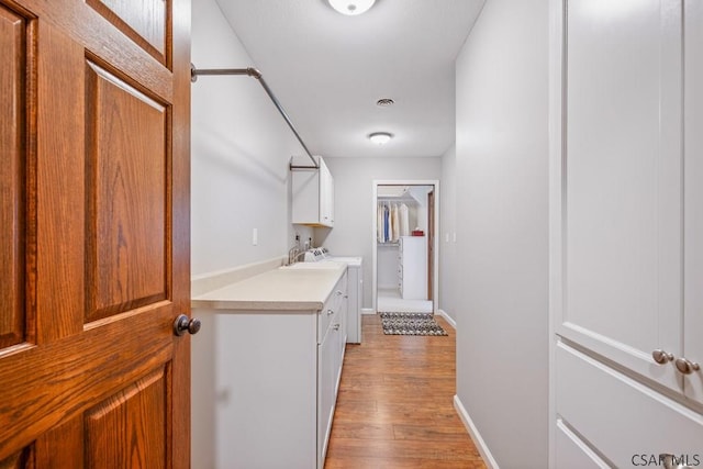 hallway featuring light wood finished floors and baseboards