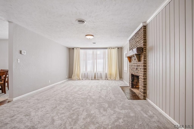 unfurnished living room featuring visible vents, a textured ceiling, carpet flooring, a brick fireplace, and a textured wall