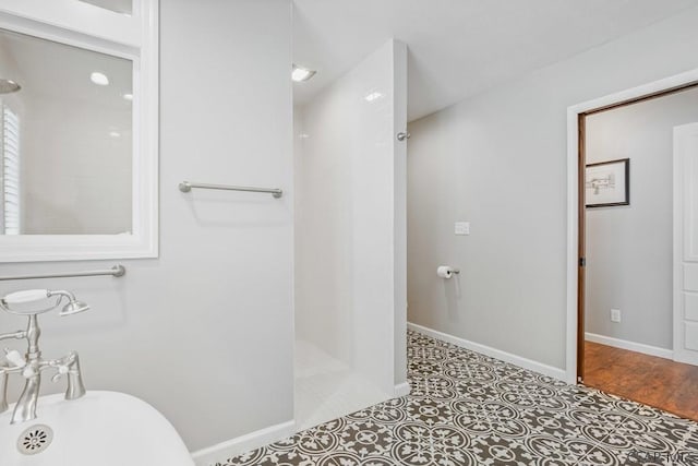 bathroom with baseboards and walk in shower