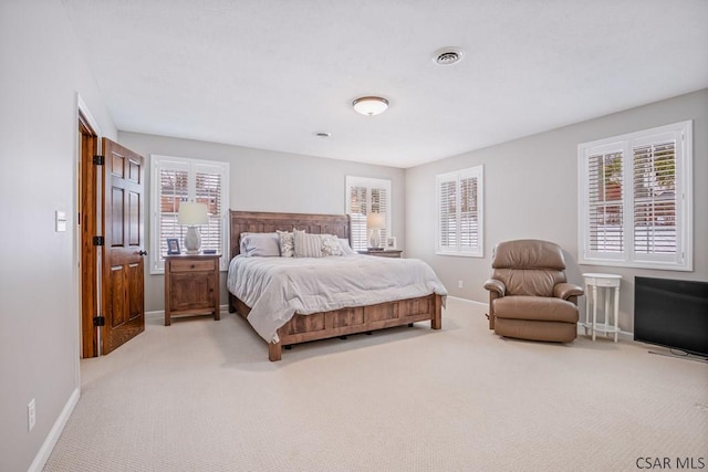 bedroom featuring visible vents, baseboards, and light colored carpet