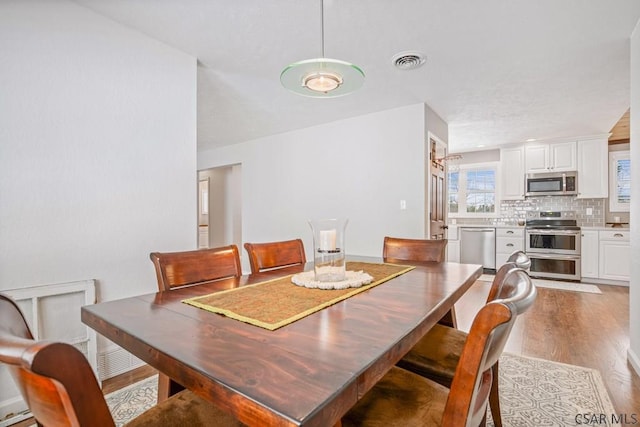 dining space with visible vents and light wood finished floors