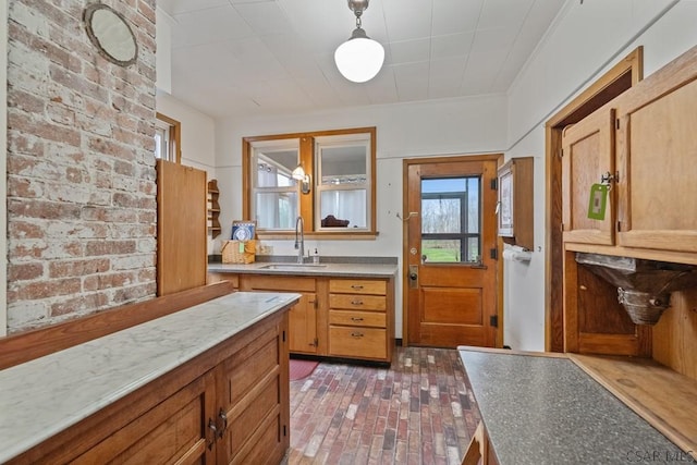 624 Oden St, Confluence, PA 15424 - kitchen featuring a sink, brick floor, hanging light fixtures, and light countertops