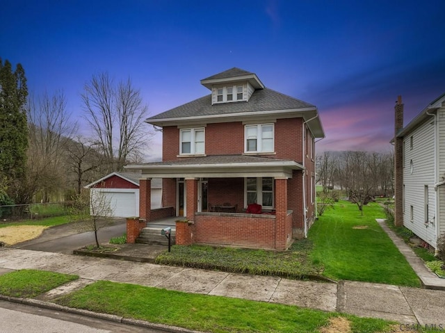 624 Oden St, Confluence, PA 15424 - traditional style home featuring a front lawn, brick siding, a detached garage, a porch, and an outdoor structure