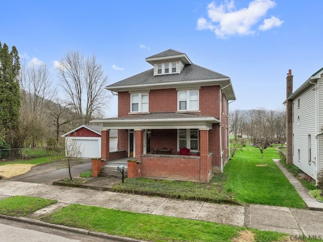 624 Oden St, Confluence, PA 15424 - traditional style home featuring a porch, a front yard, a detached garage, brick siding, and an outdoor structure