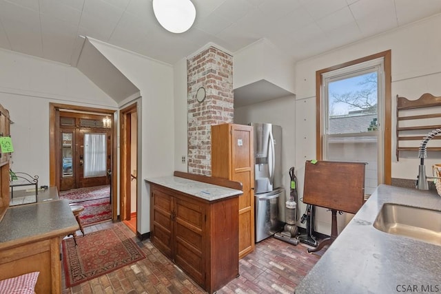 624 Oden St, Confluence, PA 15424 - kitchen featuring brown cabinets, freestanding refrigerator, a sink, and brick floor