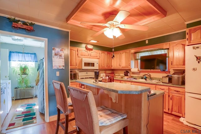 kitchen featuring light wood-style floors, white appliances, radiator, and a center island