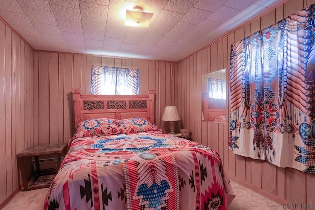 bedroom featuring wooden walls and light colored carpet