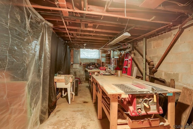 unfinished basement featuring electric panel and a workshop area