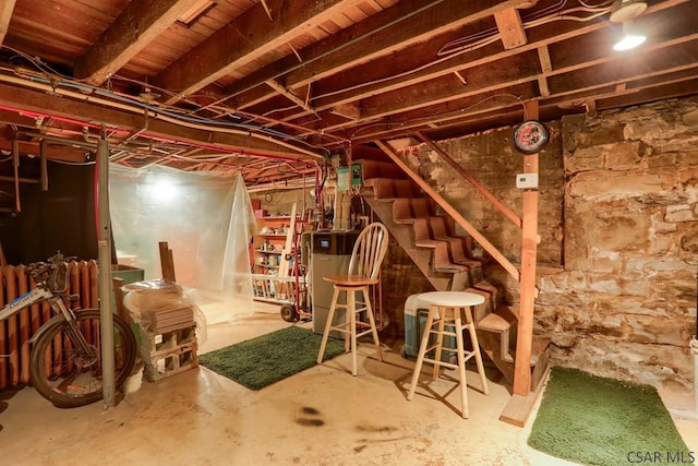 unfinished basement with stairs and water heater