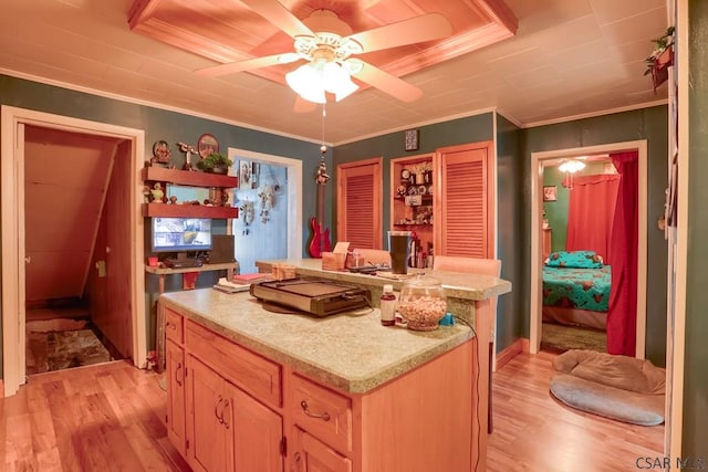 kitchen featuring light wood finished floors, light brown cabinetry, a kitchen island, crown molding, and light countertops