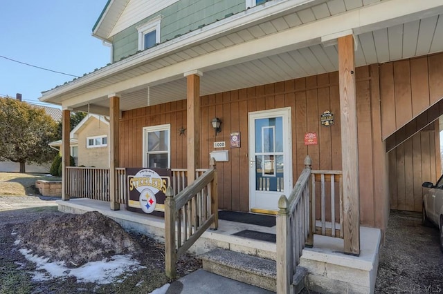 view of exterior entry featuring covered porch