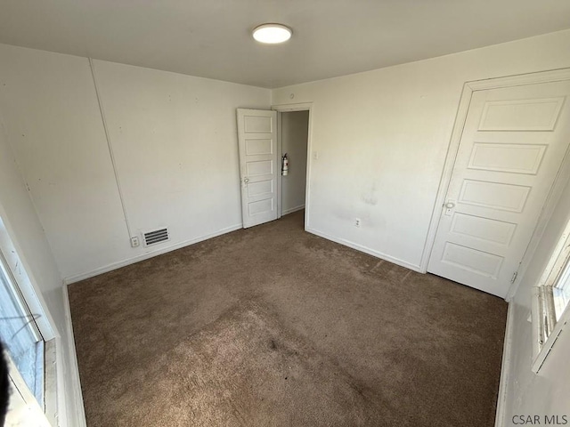 unfurnished bedroom featuring visible vents, baseboards, and carpet flooring