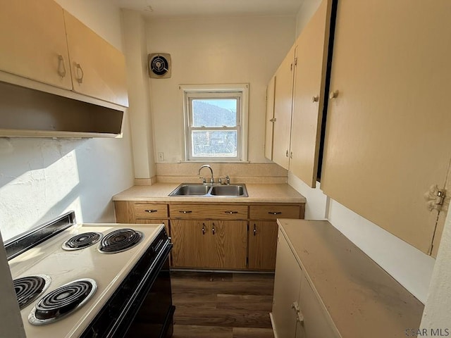 kitchen with under cabinet range hood, electric range, light countertops, and a sink