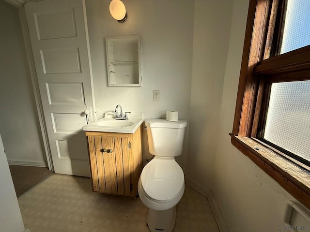 bathroom featuring vanity, toilet, and baseboards