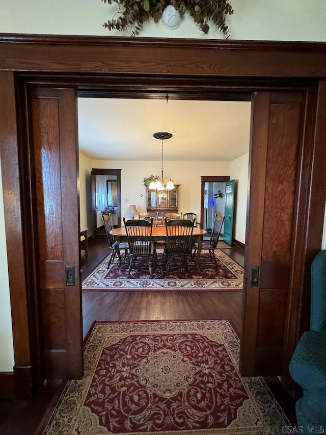 dining space featuring dark hardwood / wood-style floors and a chandelier