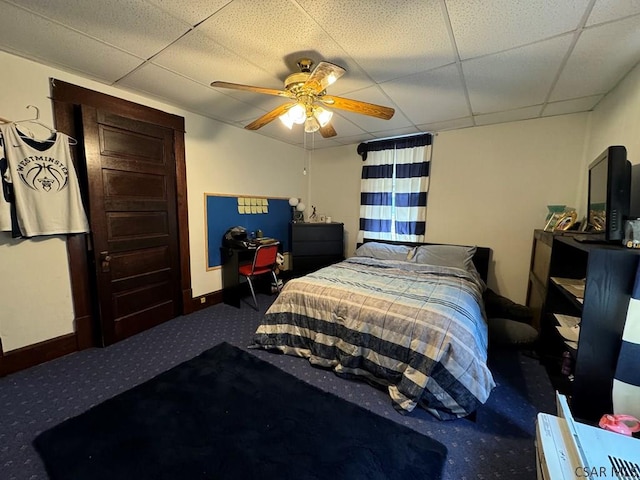 bedroom with a drop ceiling, carpet floors, and ceiling fan