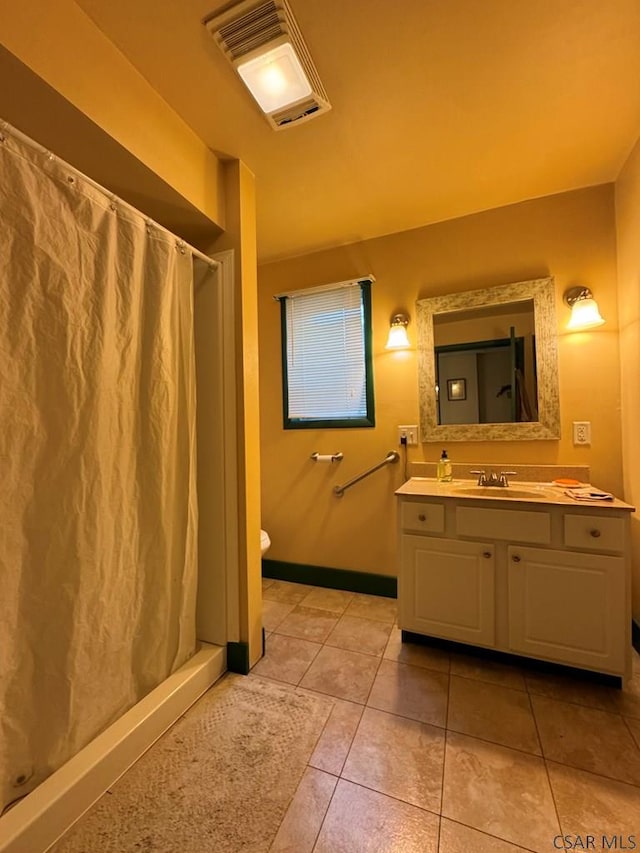 bathroom with vanity, tile patterned floors, toilet, and walk in shower