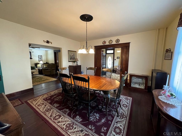 dining space featuring dark hardwood / wood-style floors and an inviting chandelier