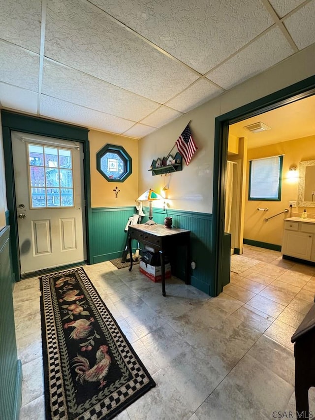 doorway featuring sink and a drop ceiling