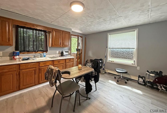 304 Oak St, Conemaugh, PA 15909 - kitchen with brown cabinetry, a sink, light countertops, and light wood-style flooring