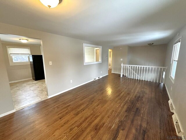 unfurnished room with a healthy amount of sunlight and dark hardwood / wood-style floors