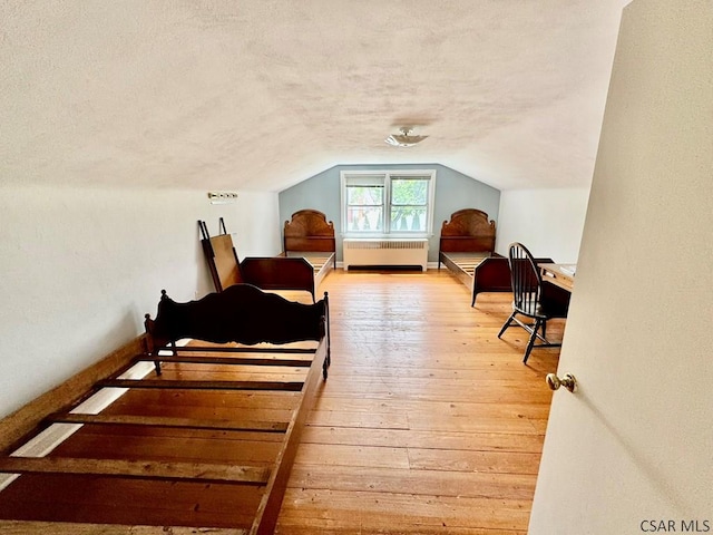 1502 Goucher St, Johnstown, PA 15905 - bedroom featuring radiator, a textured ceiling, vaulted ceiling, and hardwood / wood-style flooring