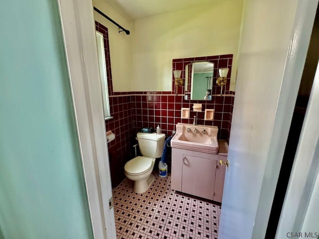 1502 Goucher St, Johnstown, PA 15905 - bathroom with toilet, wainscoting, tile walls, vanity, and tile patterned floors