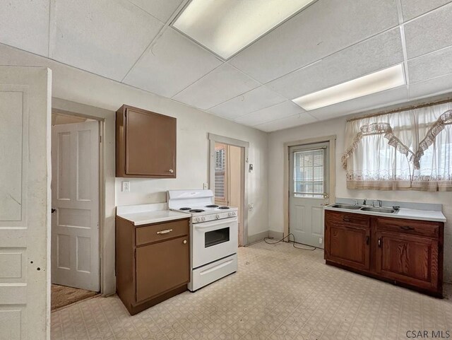 kitchen with sink, white electric range oven, and a drop ceiling