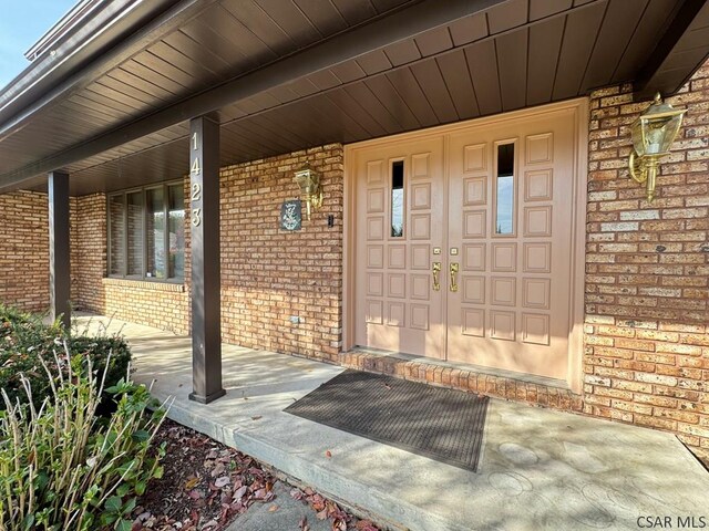 view of exterior entry featuring covered porch