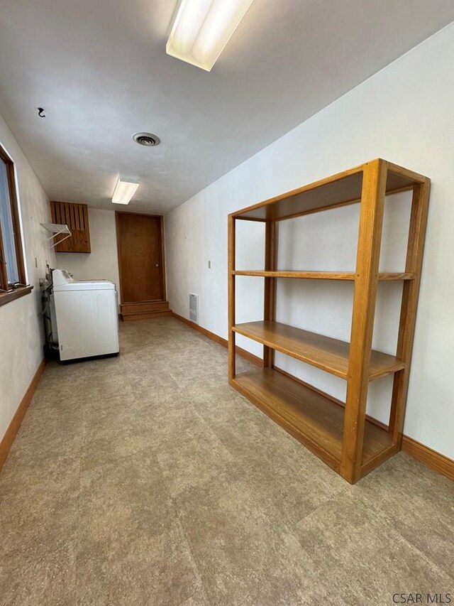 basement with washer / dryer and light carpet