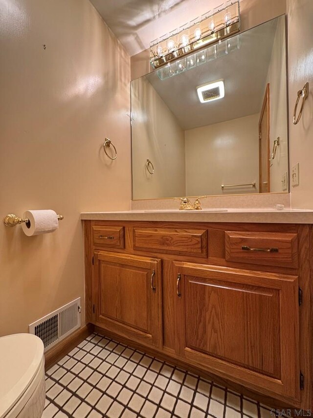 bathroom with vanity, tile patterned flooring, and toilet