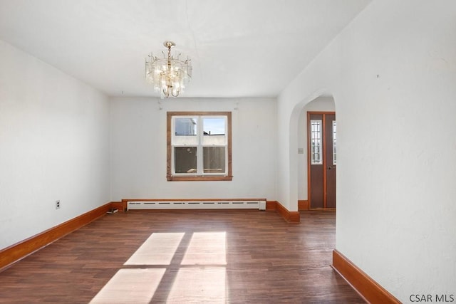 empty room with a baseboard radiator, dark hardwood / wood-style floors, and a chandelier