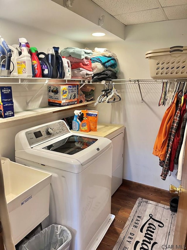 washroom with laundry area, washer and dryer, dark wood-style flooring, and a sink