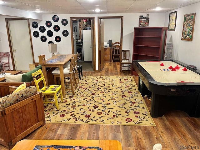 recreation room featuring a paneled ceiling and light wood finished floors