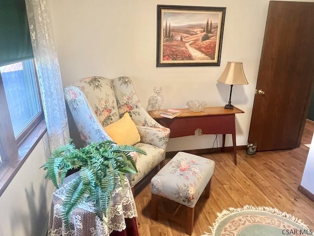 sitting room with baseboards and wood finished floors